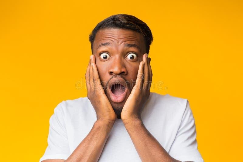 surprised black man touching face posing over orange background omg surprised black man touching face looking camera shock 169071007